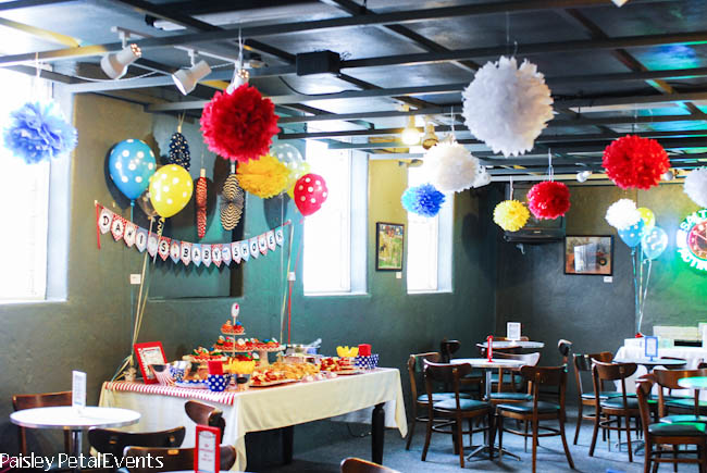 Dr. Seuss baby shower party room with red white, blue and yellow balloons & tissue poms